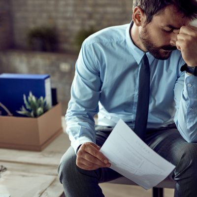Young frustrated businessman holding a CV